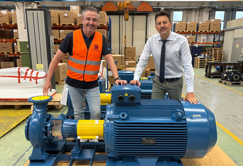 Mattias Steffl från Colly Flowtech tillsammans med Massimiliano Restelli från Pompetravaini står bredvid en stor industripump inne i Pompetravainis produktionsanläggning