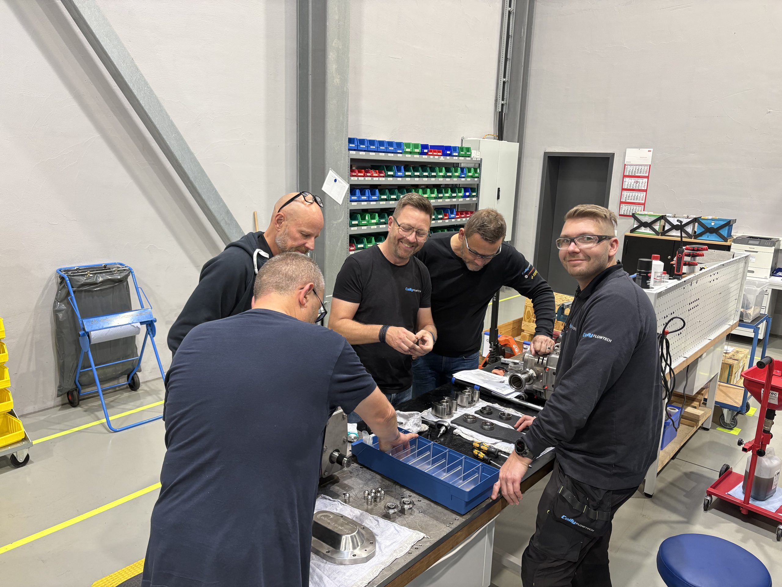 Medarbetare från Colly Flowtech och Ampco Pumps som gör en teknisk genomgång och arbetar med kolvrotorpumpar i verkstaden.