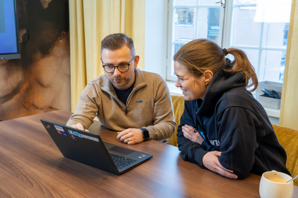 Två medarbetare från Colly Flowtech diskuterar något på en dator.