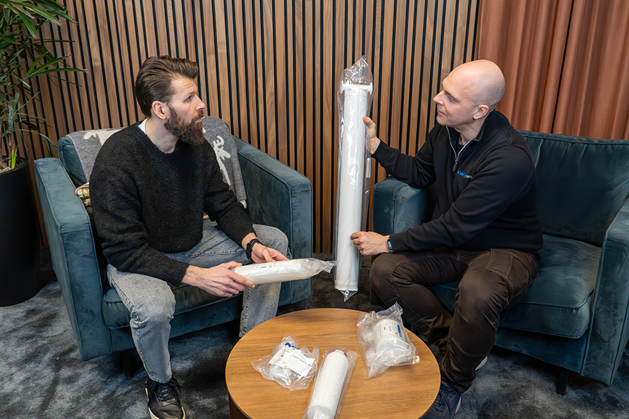 Två medarbetare på Colly Flowtech som diskuterar ett filter inom deras sortiment,